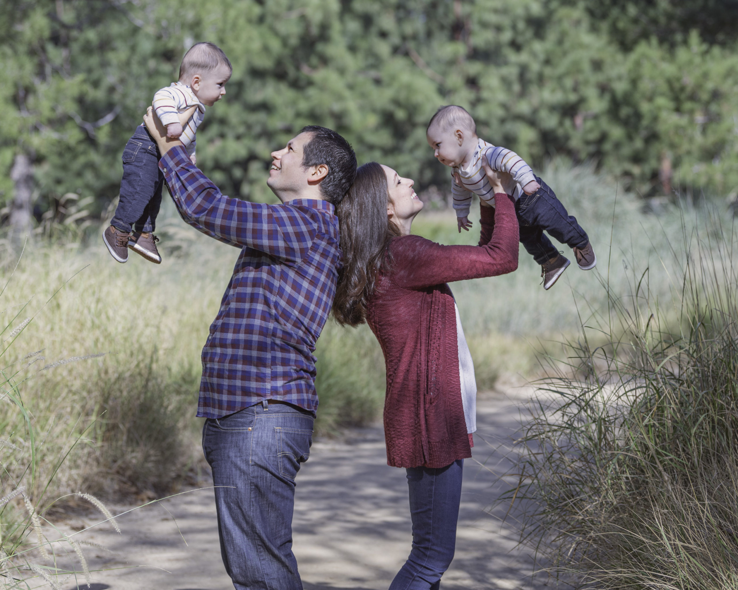 family of four in a park with the parents lifting both children in the air for their Los Angeles Family Photographer