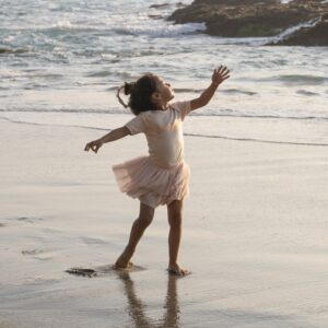 young girl running on the sand at a beach