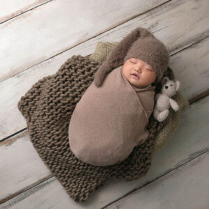 orange county newborn boy in brown wrap with teddy bear