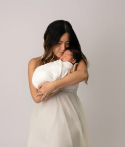 woman in white dresss holding a newborn