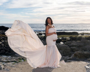 pregnant woman in light pink dress at the beach in orange county