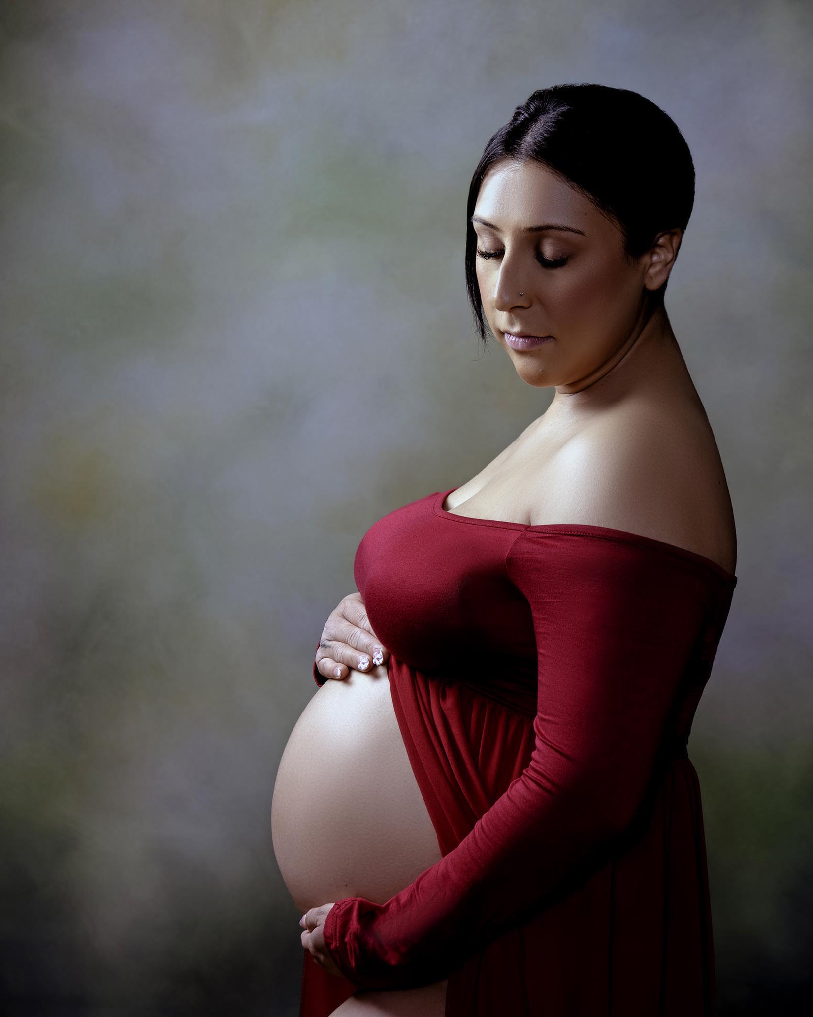 A pregnant woman in the Bay-area wearing a red gown.