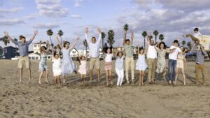 An Extended family is jumping on the beach in the Bay Area.