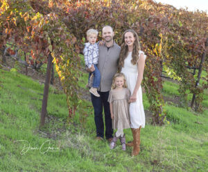 A family of four is standing in a park in Brentwood.