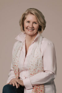 A woman is wearing a light pink blouse and is posed for the camera in the Bay Area.