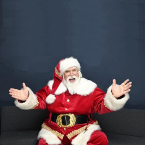 Santa is in the Bay area and sitting in a chair.