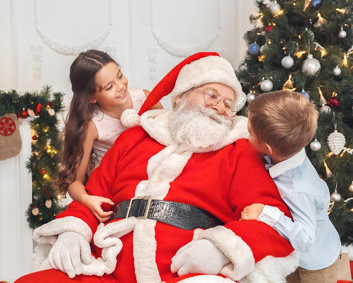A boy and a girl are visiting Santa at a Brentwood Santa mini Session.